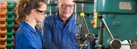 Two machinists working on machine